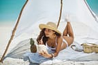 Woman Drinking Coconut Juice while Relaxing on the Beach