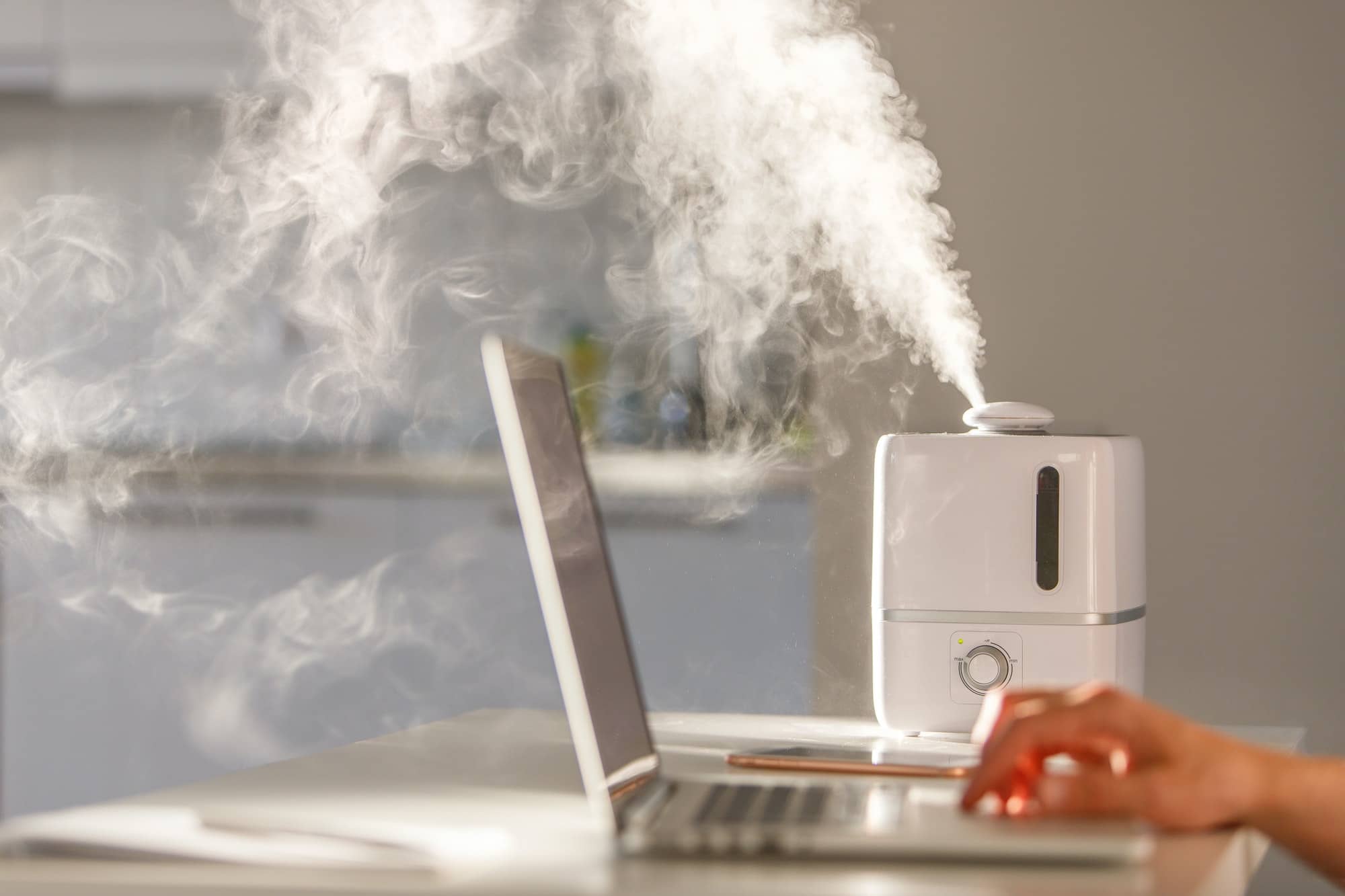 Man working on laptop near the humidifier on the table