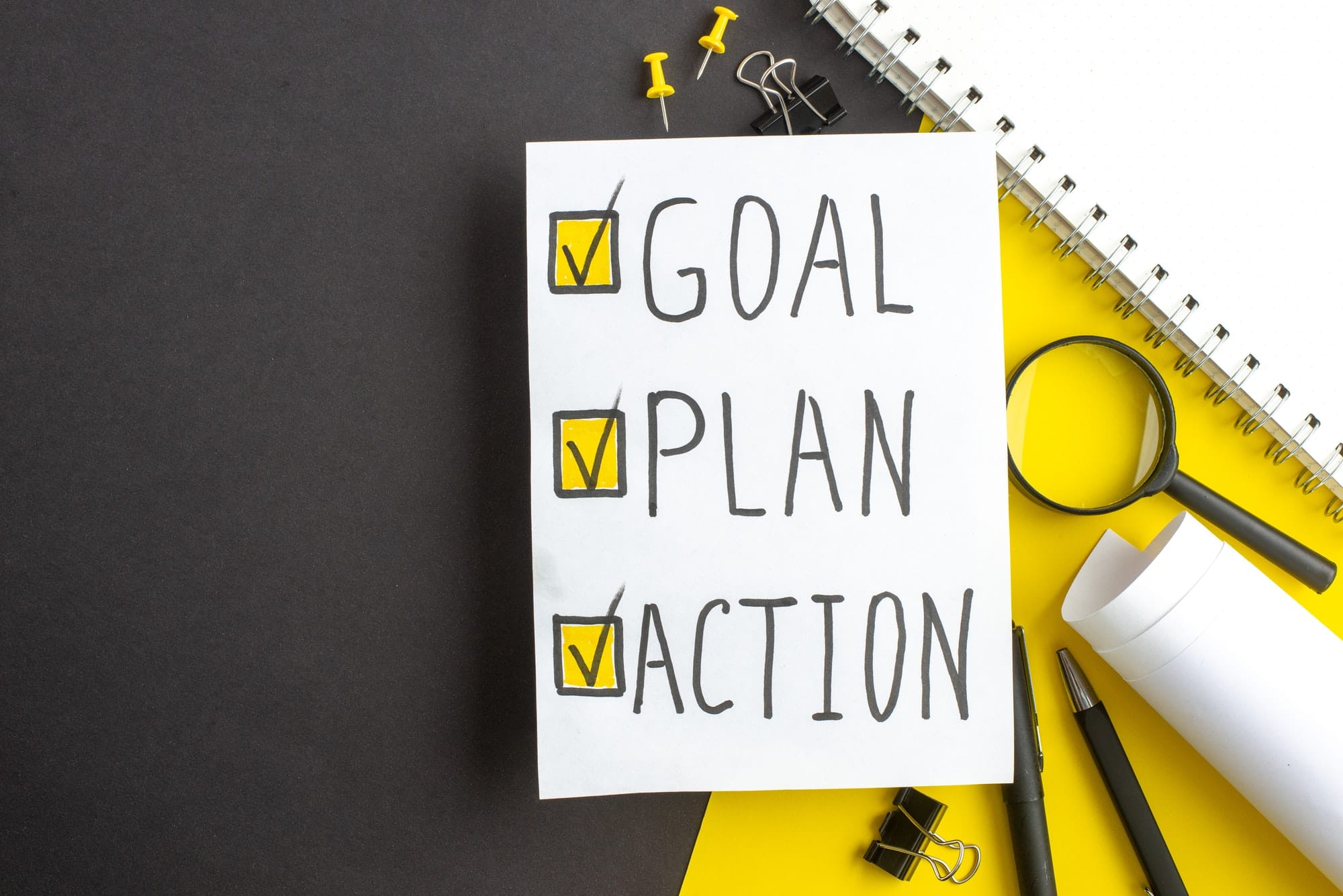 top view goal plan action notes with pens on dark-yellow background office success business