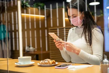 woman in cafe using smartphone on coffee break