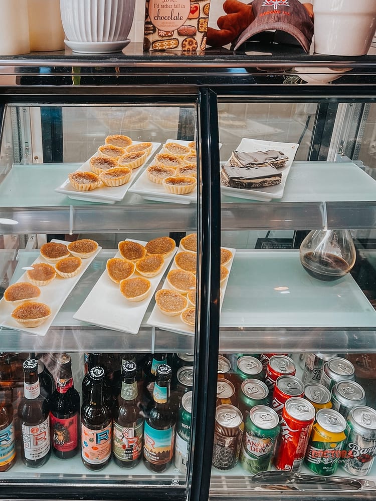 Butter tarts, Nanaimo bars & drinks in a display case